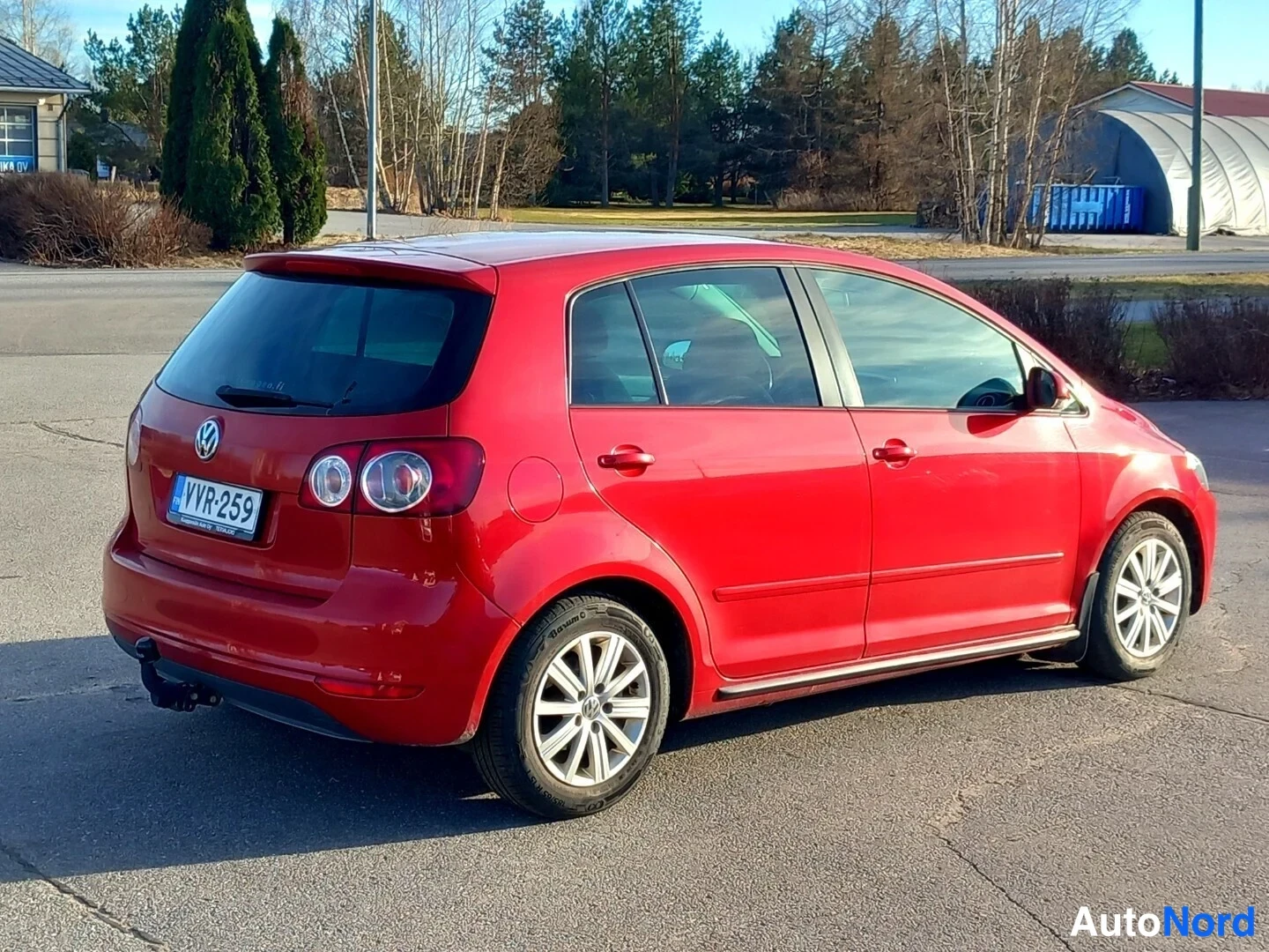 Takaviisto: Punainen Volkswagen Golf Plus takaa ja oikealta sivulta kuvattuna, rekisterikilpi, vetokoulukytkin takapuskurissa.