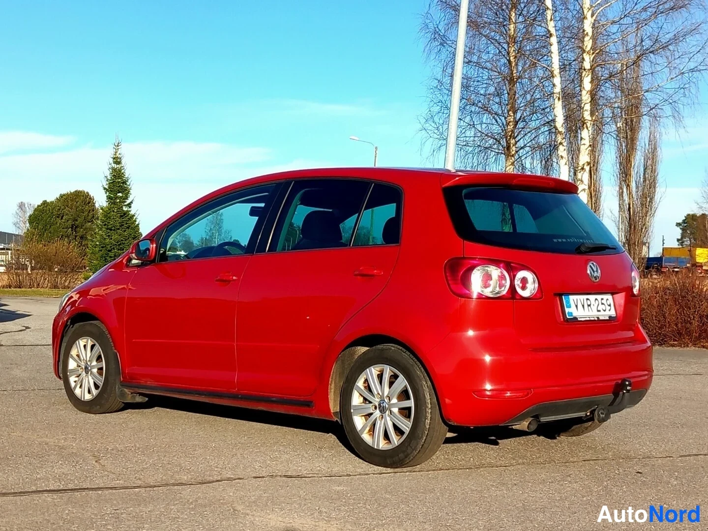 Takaviisto: Punainen Volkswagen Golf Plus takaa ja vasemmalta sivulta kuvattuna, rekisterikilpi, vetokoulu takapuskurissa.