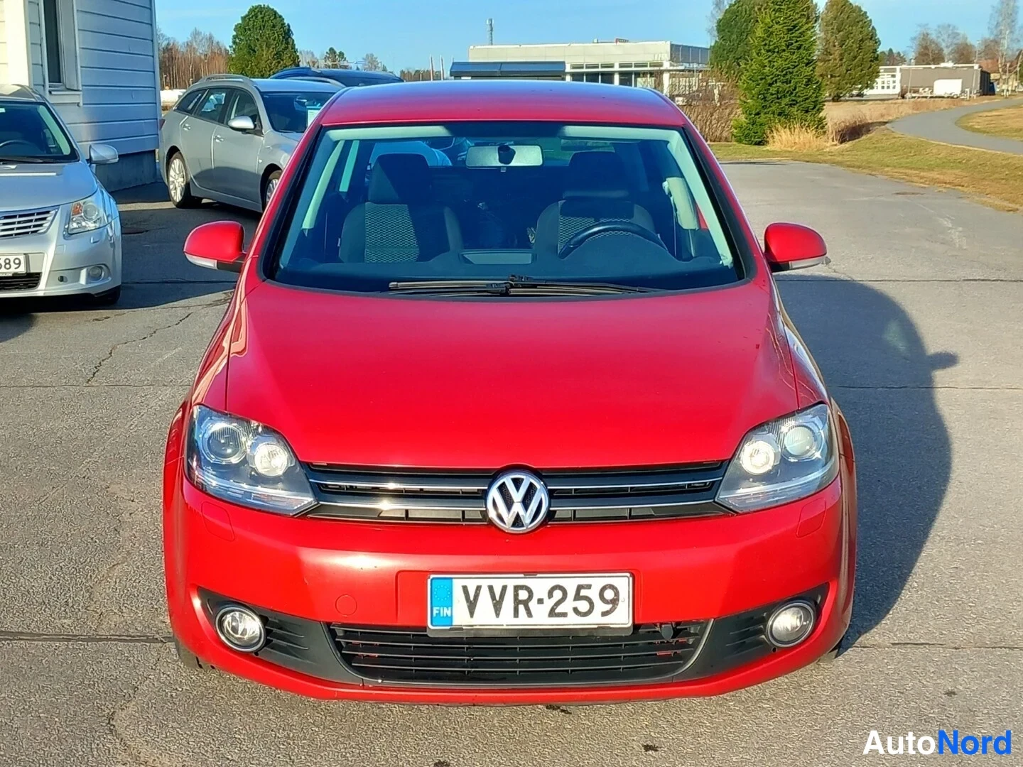 Edestä: Punaisen Volkswagenin etukuva, rekisterikilpi.
