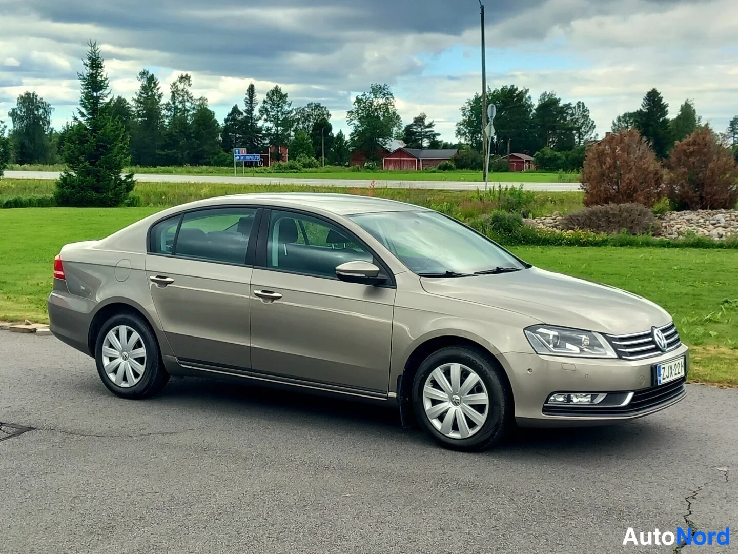 Etuviisto, nokka oikealle: Volkswagen Passat -sedan edessä ja kyljessä oikealta kuvattuna, vaaleanbeige kori.