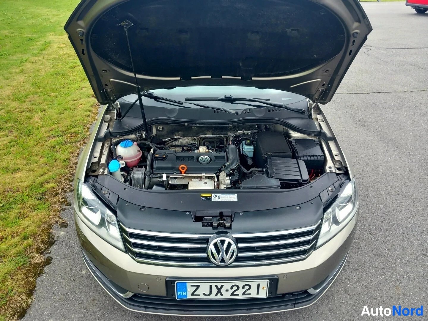 Edestä: Volkswagenin konepellin alla avattu moottoritila, etupuskurissa rekisterikilpi.