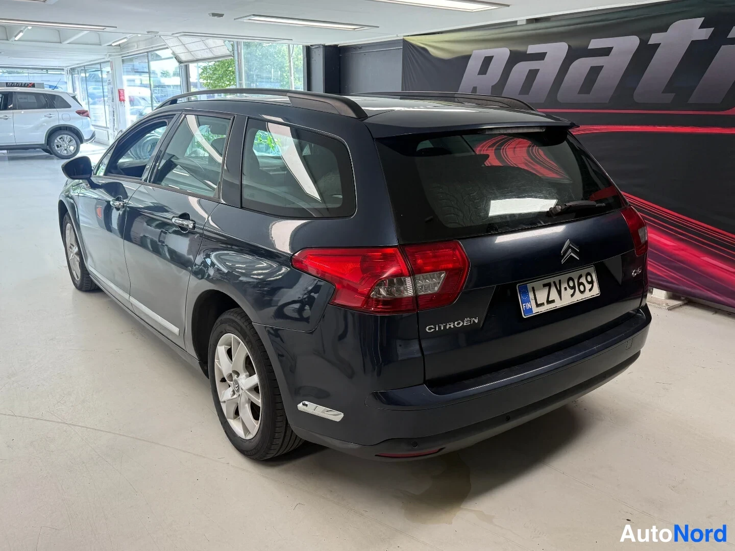 Takaviisto: Citroen C5 -farmari takaa vasemmalta kolmivartaloasennossa, rekisterikilpi ja CITROËN-teksti takaluukussa näkyvät.