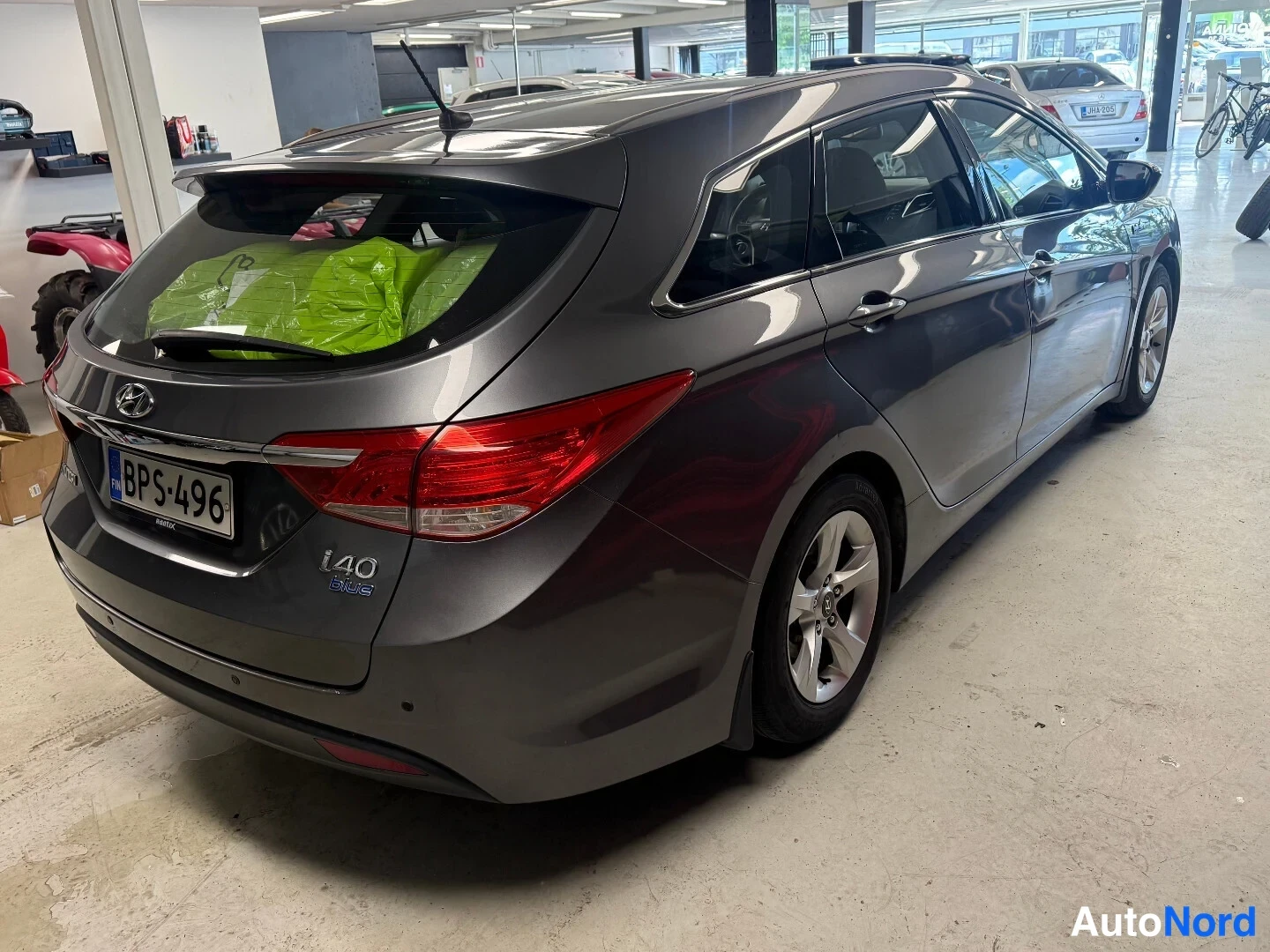 Takaviisto: Hyundai i40 -farmarin takaosa ja sivu kolmannesvinkelissä, rekisterikilpi, i40 Blue -merkintä takaluukussa.