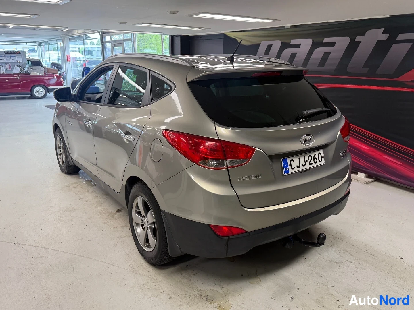 Takaviisto: Hyundai ix35 takaa oikealta kolmannesaulakulmassa, punaiset takavalot ja Blue Drive-takakirjaus näkyvissä, rekisteri.