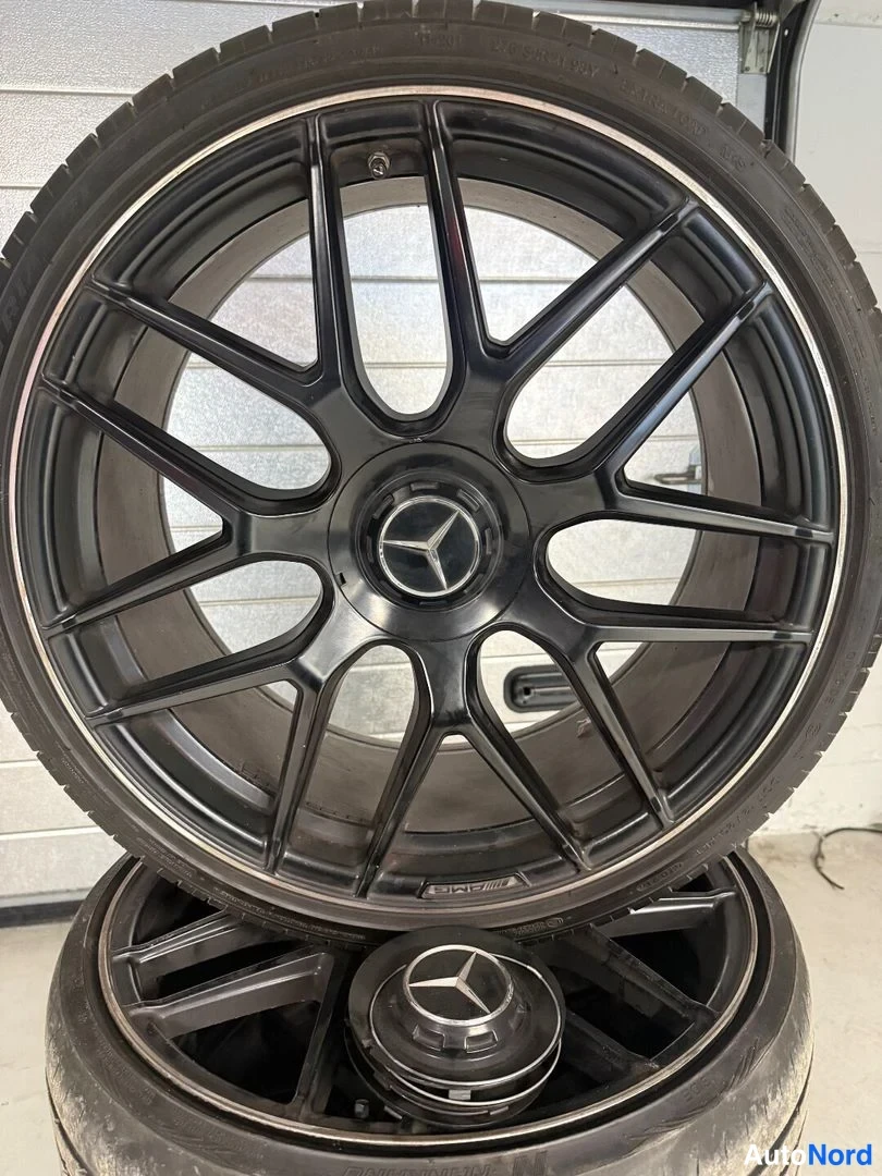 Yksityiskohta: Musta Mercedes-vanne ja kaksi rengaa pinossa