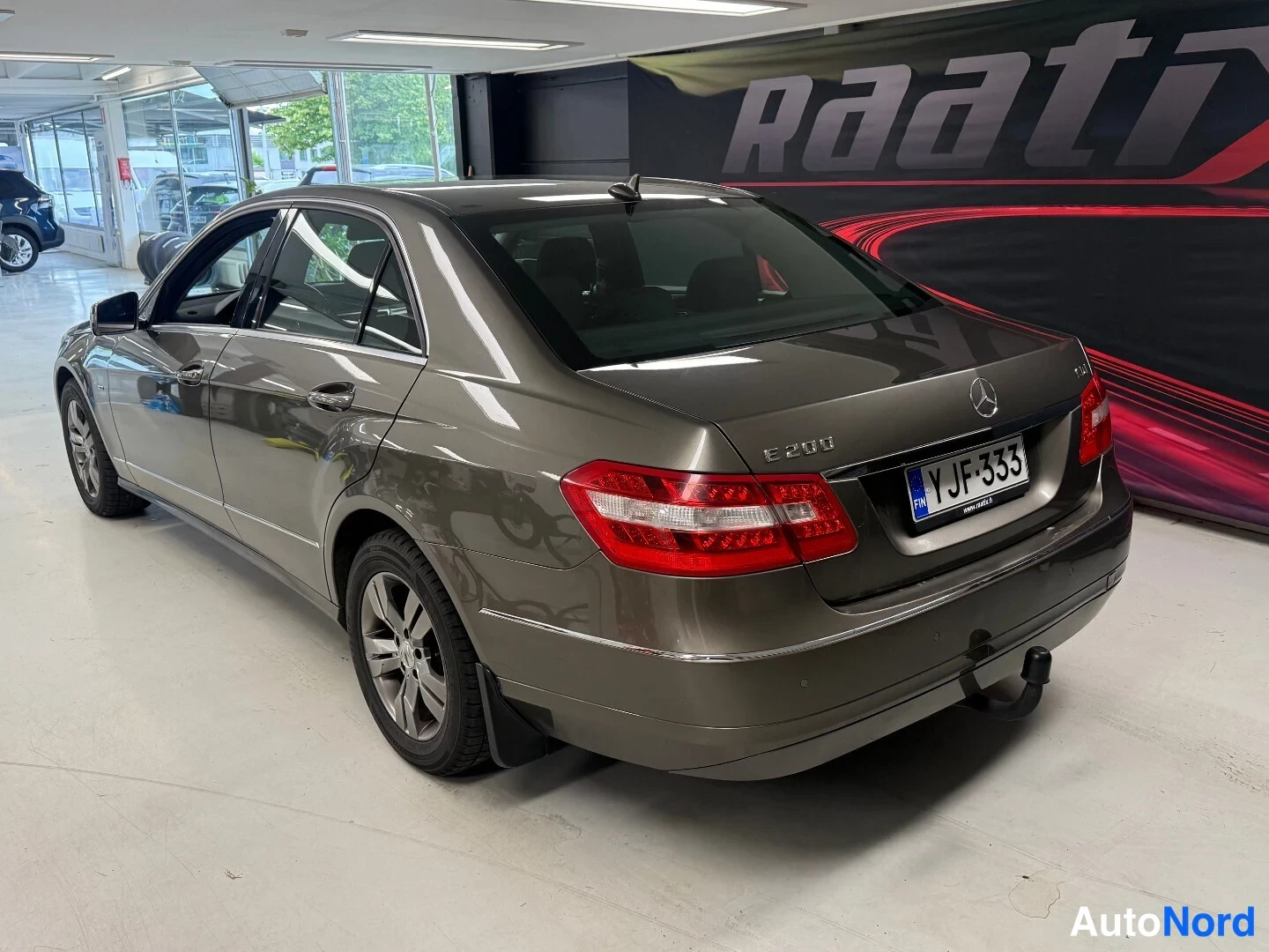 Takaviisto: Mercedes-Benz E-sarjan sedan takaosaa ja vasenta sivua oikealta sivulta kuvattuna, rekisteri.