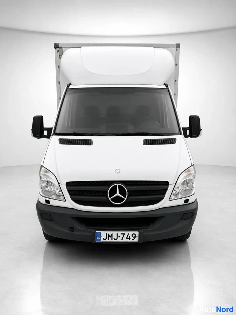 Edestä: Mercedes-Benz Sprinter -kuorma-auton etunäkymä studiossa, valkoinen koristus ja musta etusäleikkö, rekisterikilpi.