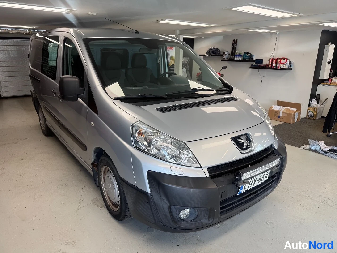 Etuviisto, nokka oikealle: Peugeot Expert -pakettiauto etukulmasta oikealta, hopeanvärinen, rekisterikilpi.