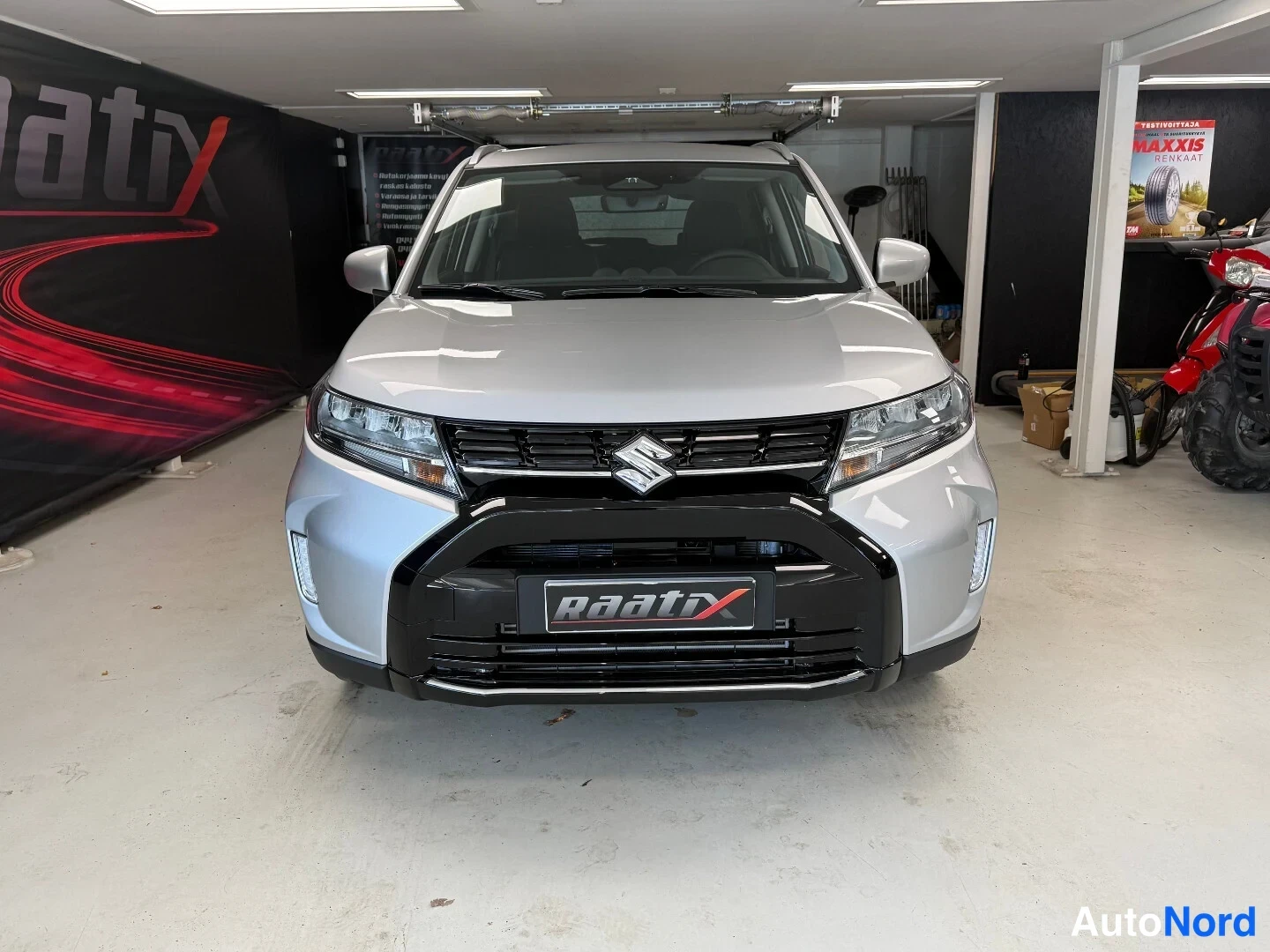 Edestä: Hopeinen Suzuki Vitara edestä, etusäleikkö ja merkki näkyvät.
