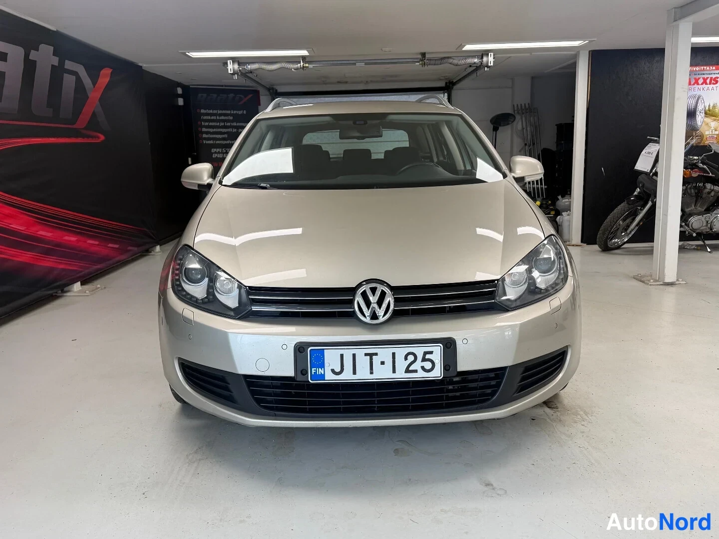 Edestä: Volkswagen Golf farmari edestä kuvattuna, rekisteritunnus, vaaleanbeige kori.