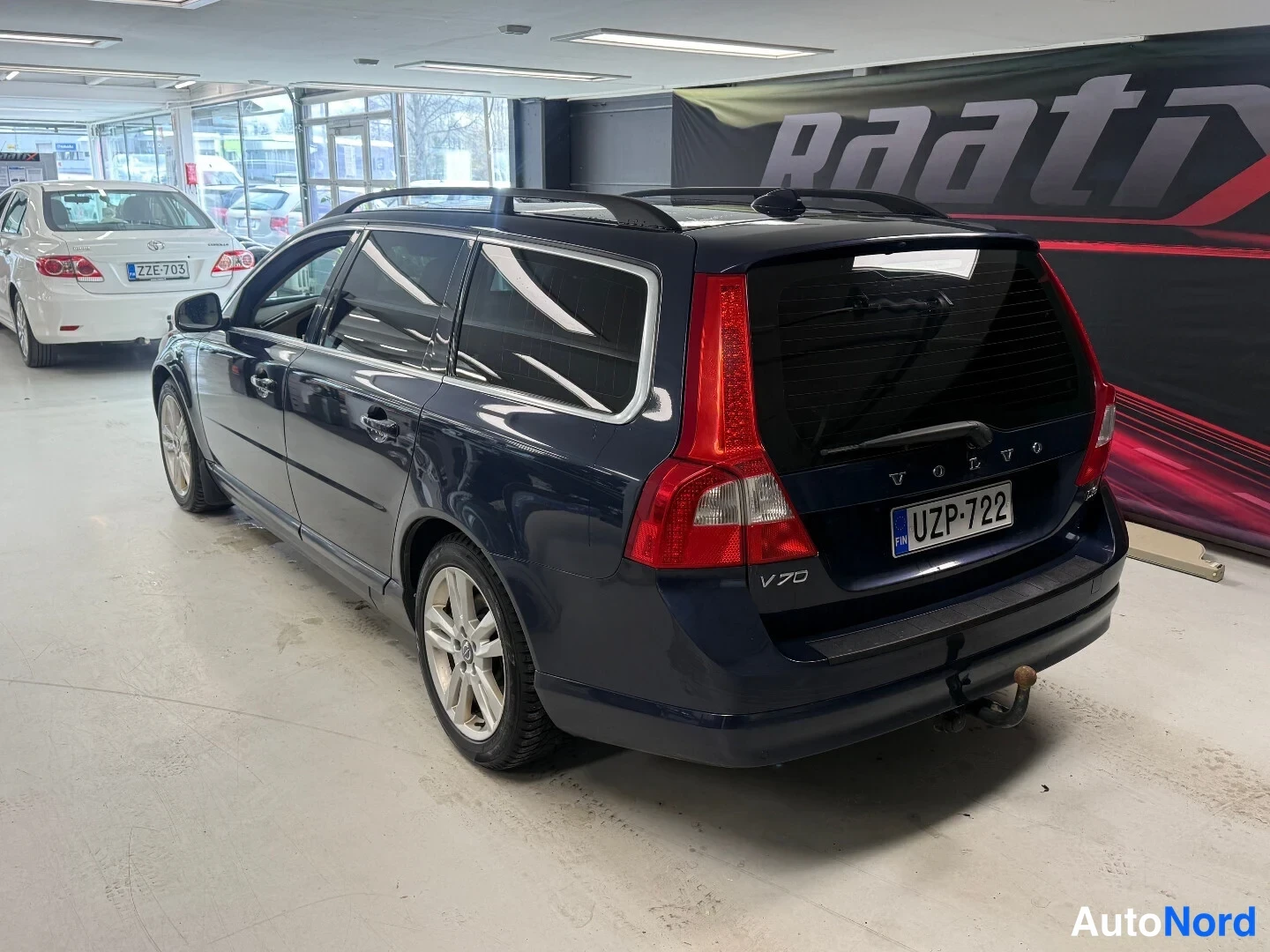 Takaviisto: Farmariauto takaa vinosti kuvattuna, rekisterikilpi ja luistot takalaudan alla.