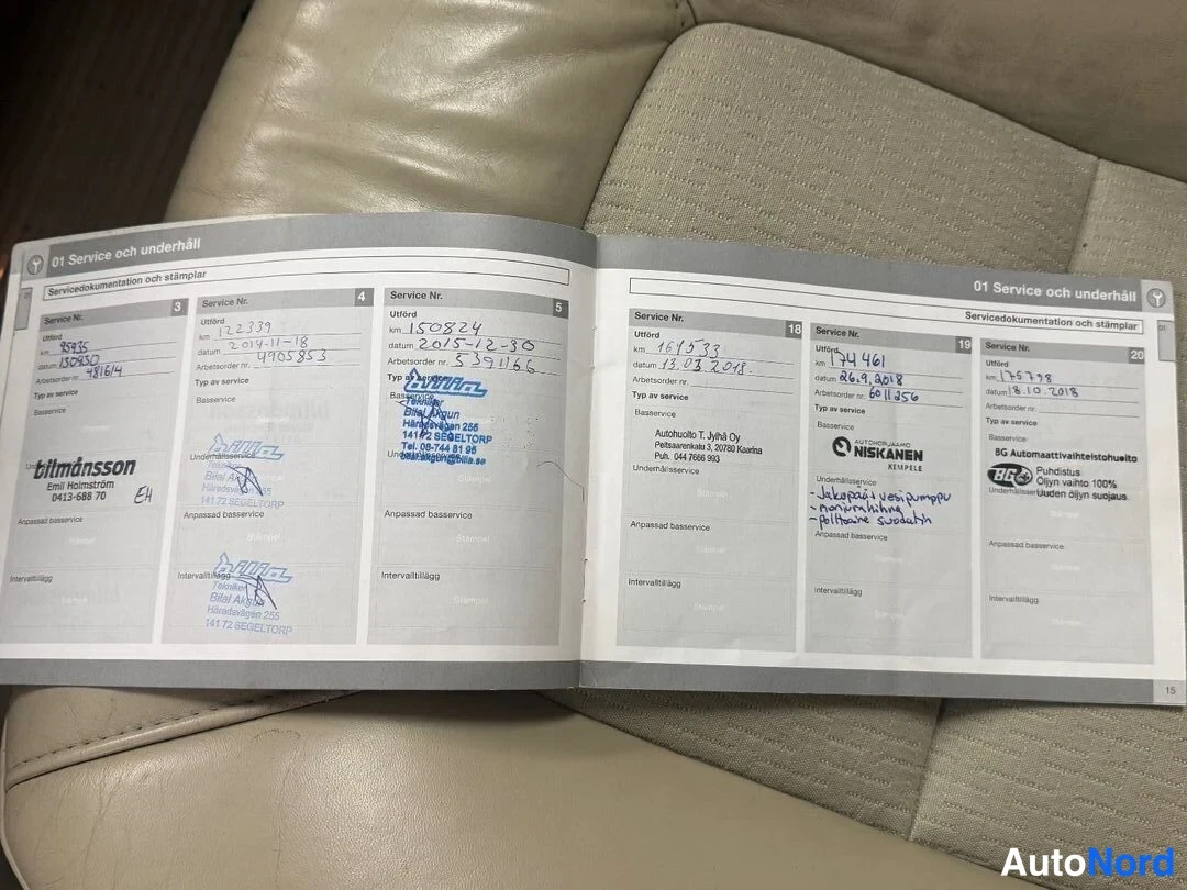 Asiakirja: Service book open on beige leather seat showing service records with stamps and handwritten dates and mileage for entries numbered 3 to 5 and 18 to 20