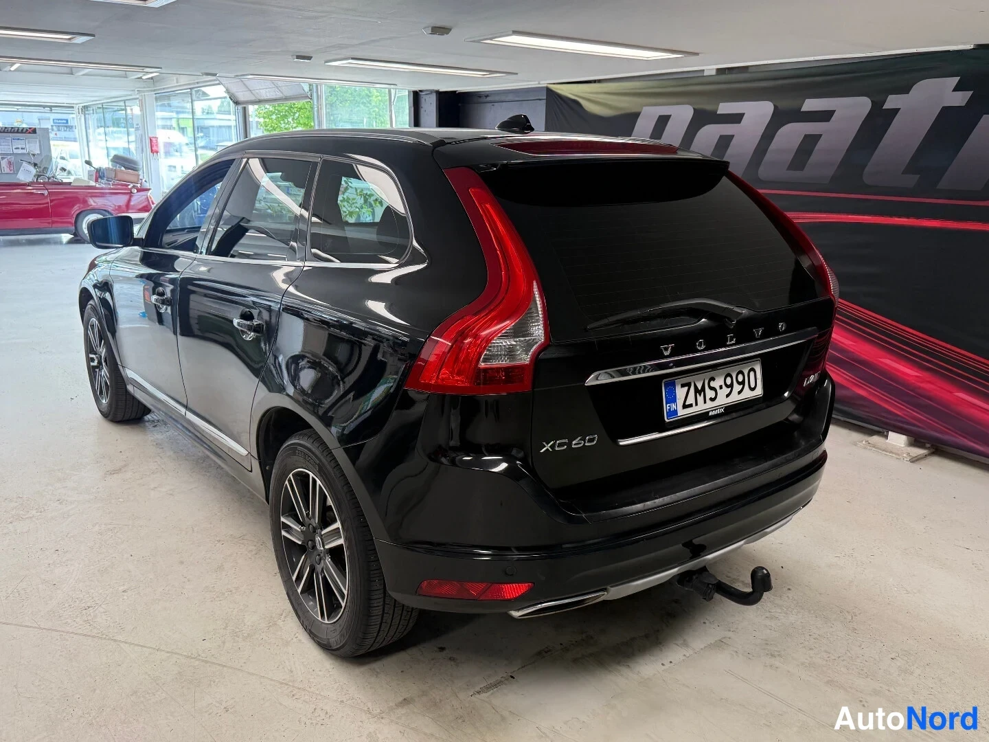 Takaviisto: Mustan Volvo XC60:n takakulma kuvattuna oikealta, rekisteritunnus ja takakytkimen koukku näkyvät.