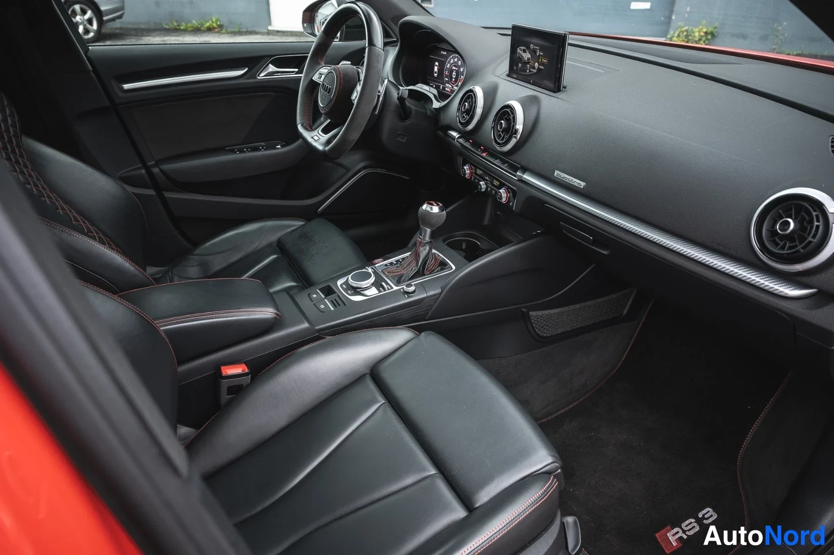 Muu: Takaistuimelta kuvattu kojetaulu: Audi-ohjauspyörä, Virtual Cockpit -mittaristo, keskikonsoli ja RS 3 -merkillinen matto.