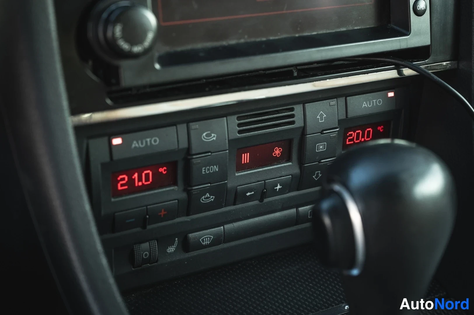 Muu: Kaksivyöhykkeinen automaattinen ilmastointipaneeli, lukemat 21,0 °C ja 20,0 °C, ECON- ja AUTO-painikkeet sekä vaihtajankea.