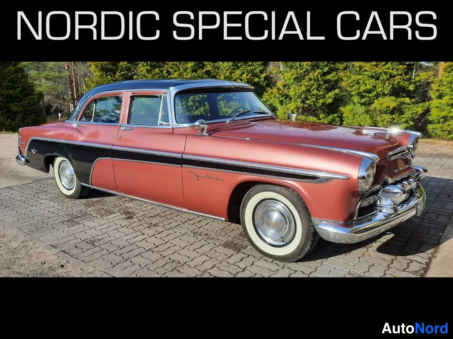 Etuviisto, nokka oikealle: Kaksivärinen DeSoto Fireflite -henkilöauto punakuparisella koria ja mustalla katolla, kuvattu kolmannelta etuosasta vasemmalla kylki näkyvissä.