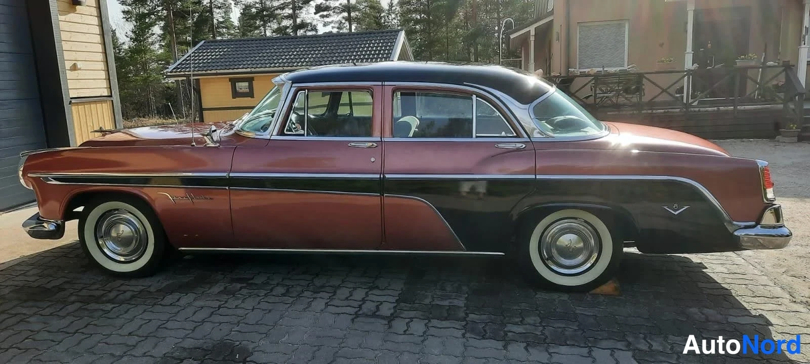 Sivulta: DeSoto Fireflite -henkilöauton sivukuva; kaksivärinen kuparinpunainen-korimusto kori, valkorengaskummat ja kromikoristeet näkyvät täysin.