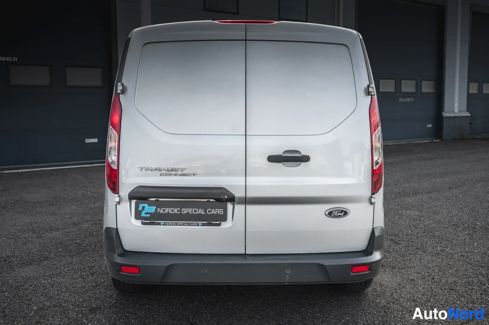 Takaa: Ford Transit Connect -pakettiauton takaosa suoraan takaa valokuvattuna; kaksiosaiset takaovet, Transit Connect -teksti ja Ford-merkki takaluukussa.