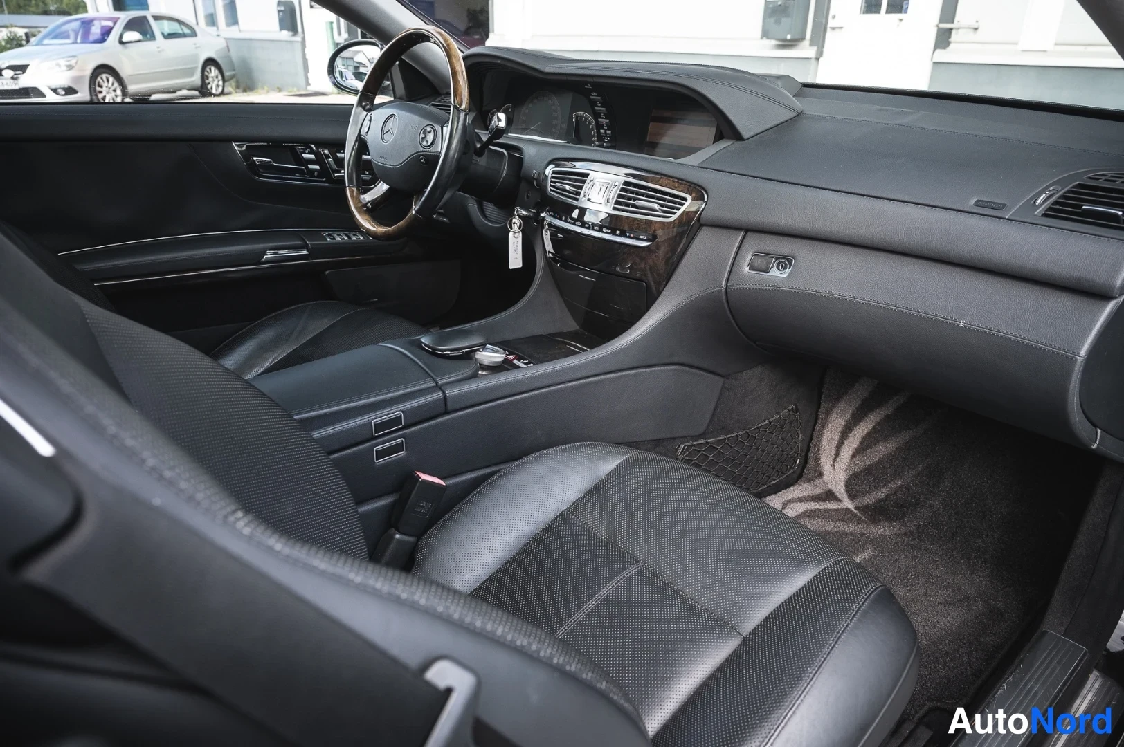 Muu: Musta nahkainen Mercedes-Benzin sisätilat sivusta: kojelauta, keskikonsoli ja etuistuimet.