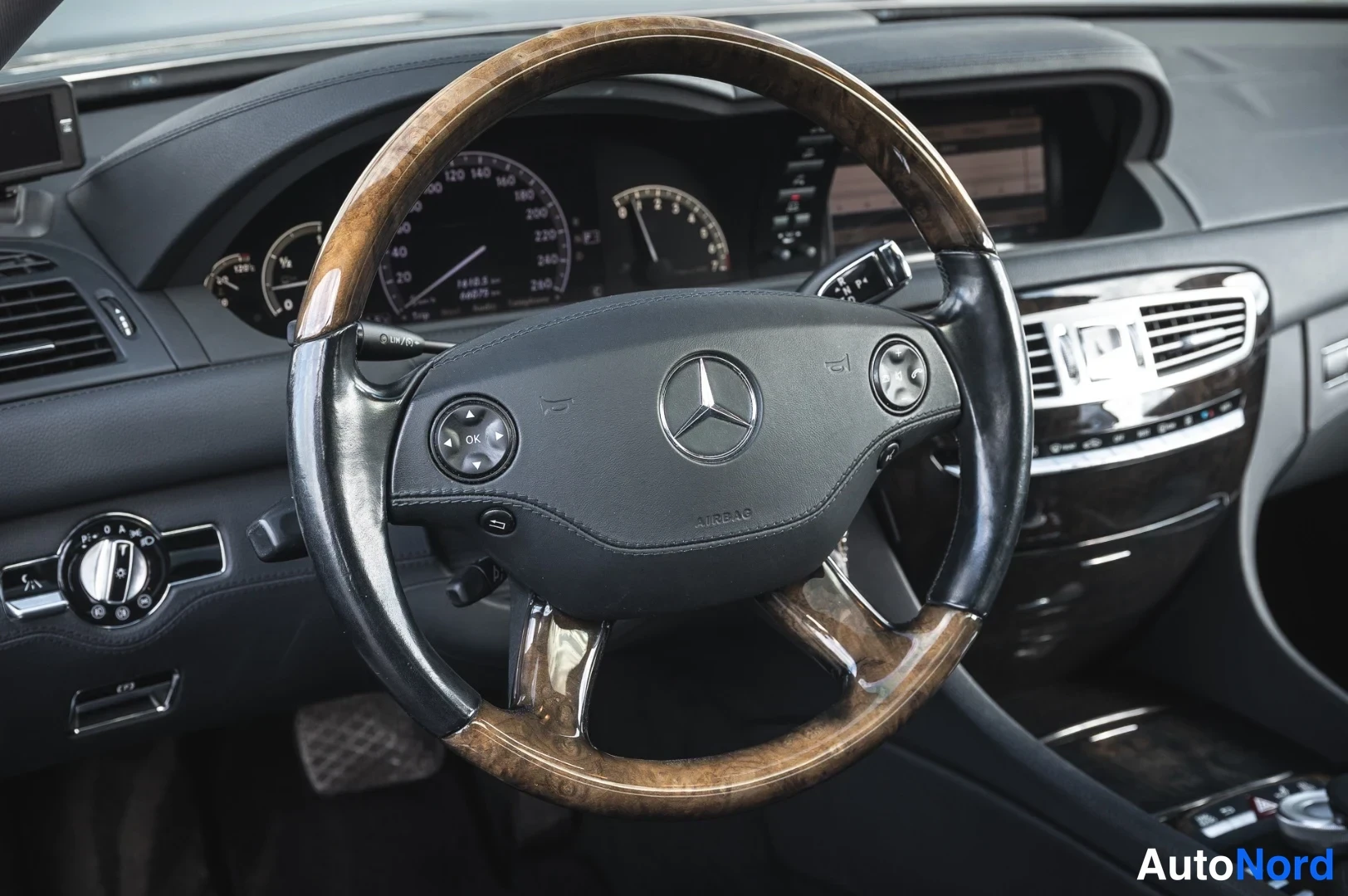 Muu: Sama ohjaamo kuin edellisessä kuvassa: puupintainen ohjauspyörä ja Mercedes-merkki.
