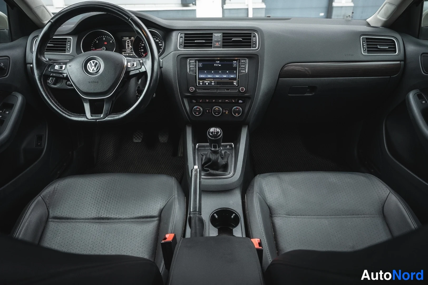 Muu: Kojelaudan etunäkymä: Volkswagen-ohjauspyörä, mittaristo ja kosketusnäyttöradio. Vaihtaja on manuaali.