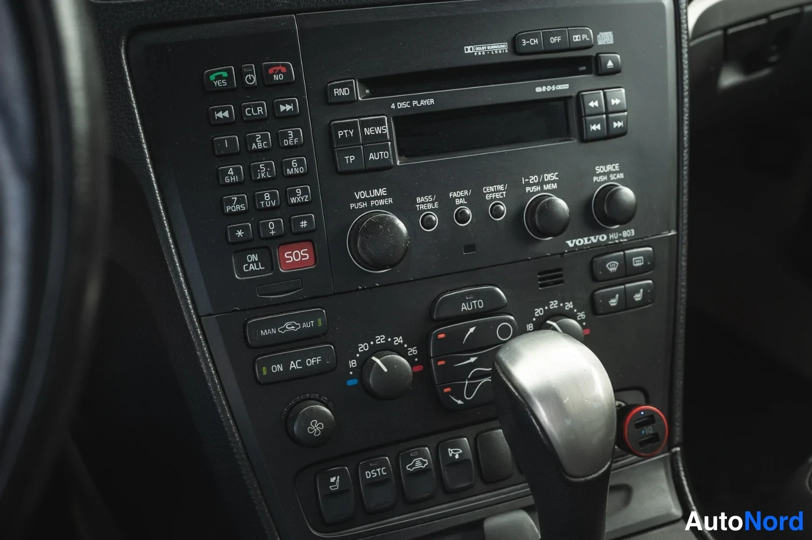 Yksityiskohta: Kojelaudan keskusyksikkö: Volvo HU-803 radio-CD-soitin, puhelinpainikkeet (YES, NO, SOS, ON CALL), ilmastointiautomaation AUTO- ja lämpötilasäädöt, DSTC-painike