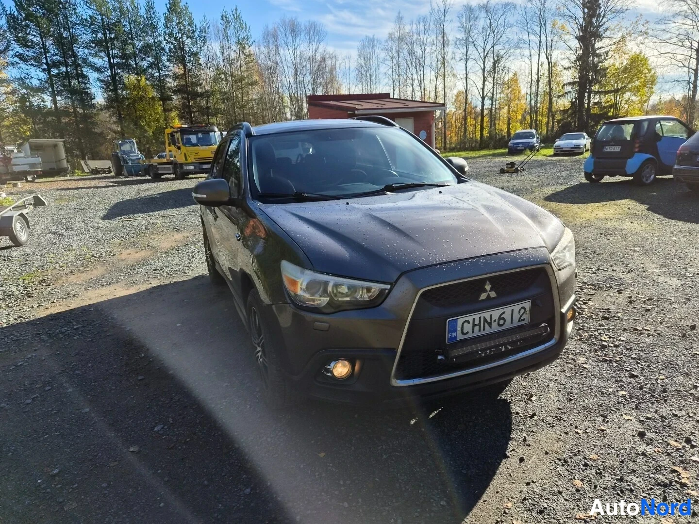 Edestä: Tummanharmaa Mitsubishi ASX edestä, rekisteritunnus ja Mitsubishi-logot etusäleikössä.