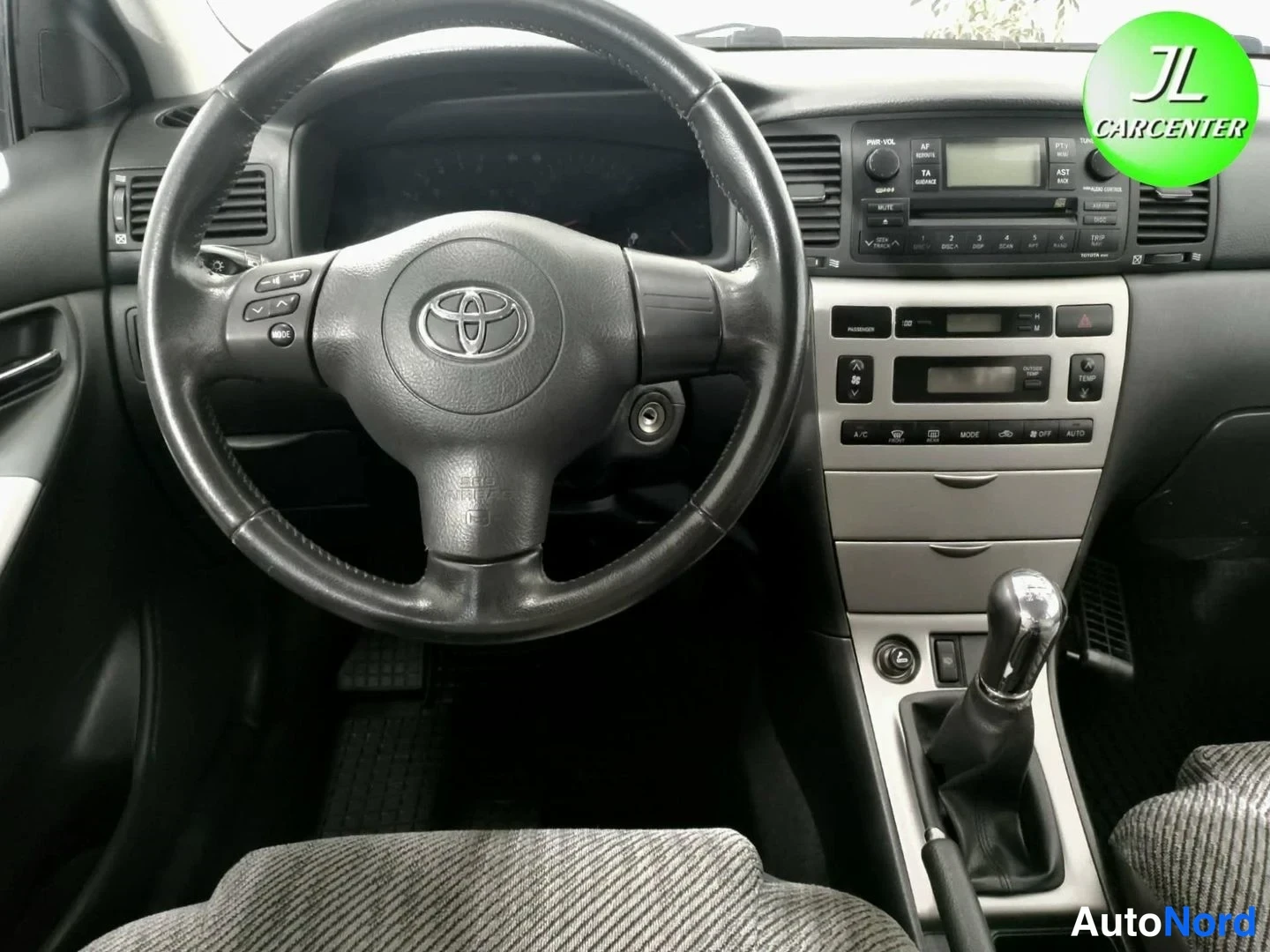 Muu: Kuljettajan näkymä Toyota-merkkiohjauspyörään, kojelautaan ja manuaali vaihteenvaihtimeen.