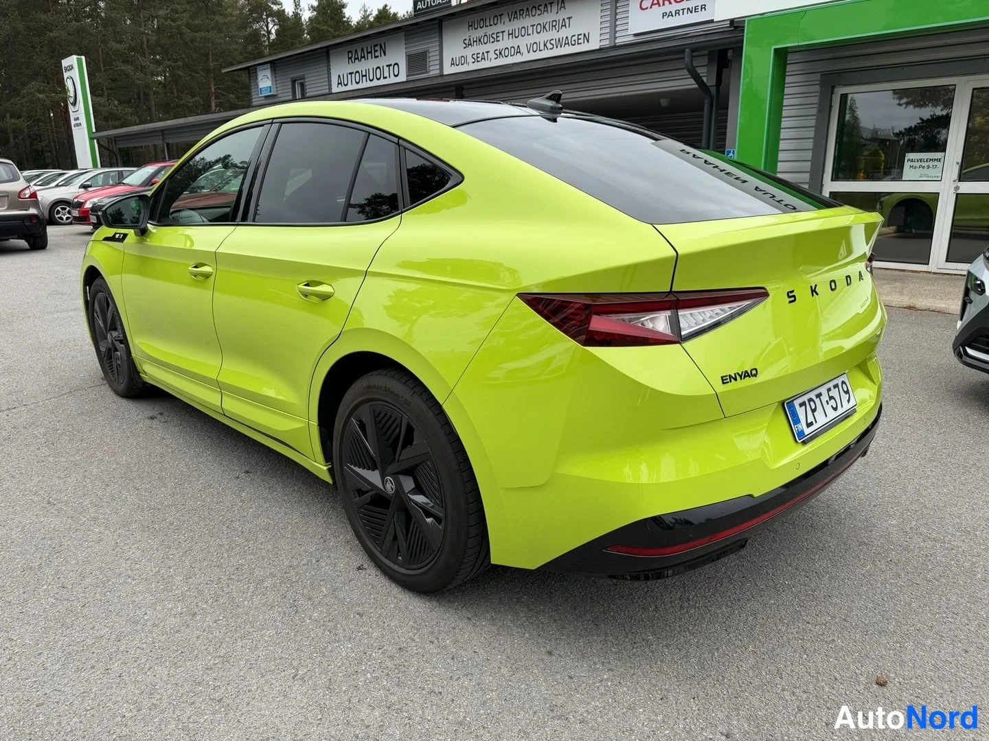 Takaviisto: Kirkkaanvihreän Skoda Enyaq Coupén taka-3/4-kuva, rekisteritunnus ja SKODA- ja ENYAQ-tekstit takaluukussa.