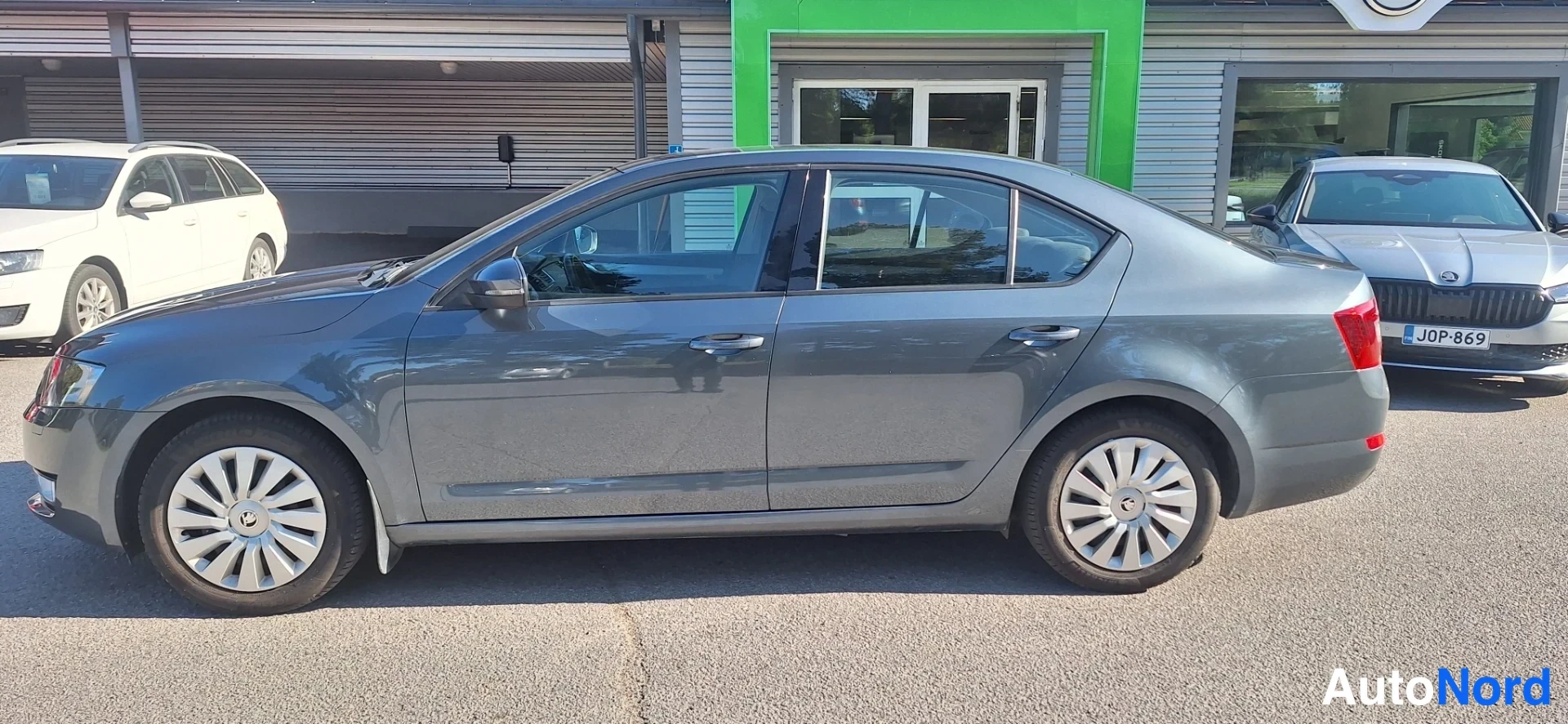 Sivulta: Skoda Octavia -sedan sivukuva vasemmalta, hopeanharmaa koripelti ja koko auto näkyvissä.