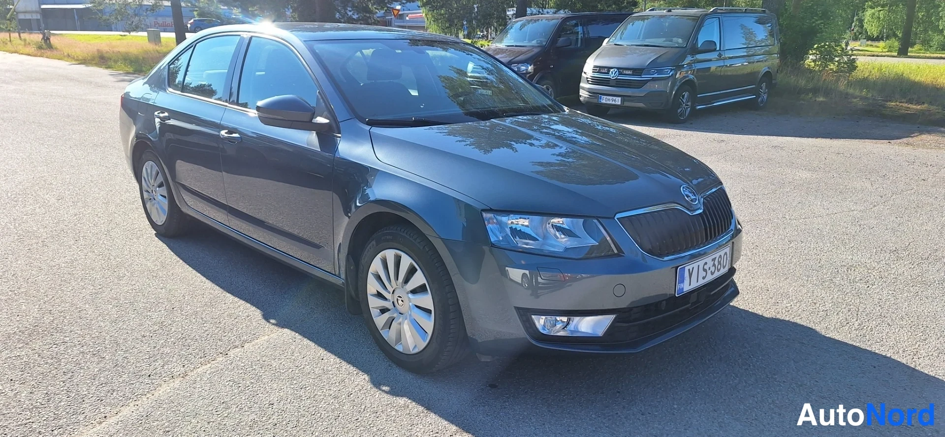 Etuviisto, nokka oikealle: Tummansinisen sedanin etukulma: Škoda-ilmastointi, rekisterikilpi.