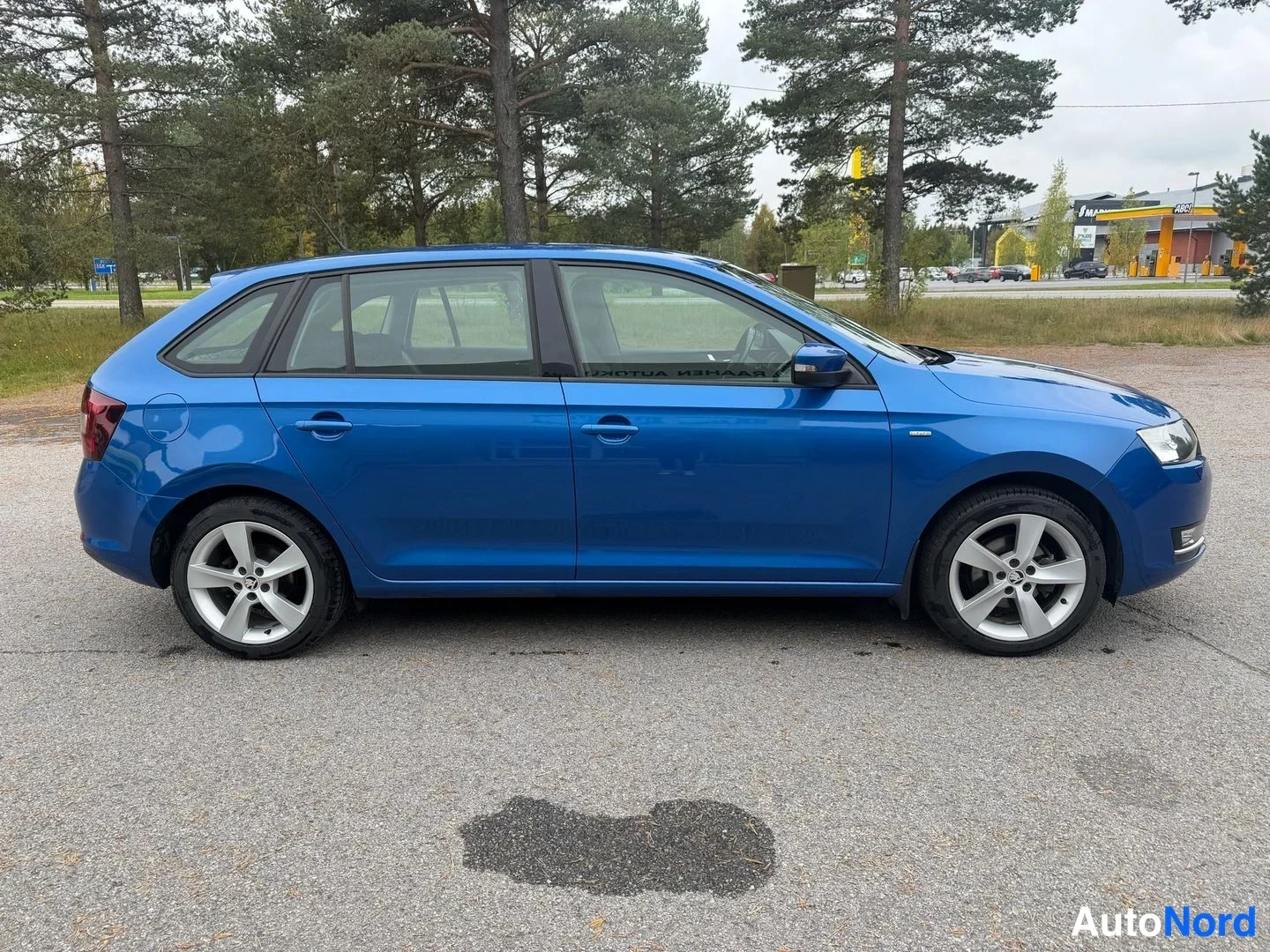 Etuviisto, nokka oikealle: Sininen Skoda Rapid Spaceback -farmariauto sivulta oikeaan viistosti kuvattuna.