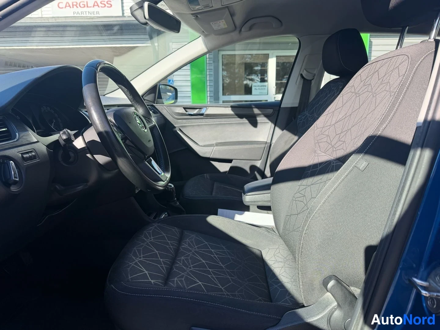 Sivulta: Skoda Rapid Spacebackin etuistuimet ja ratti sisätiloissa kuvattuna.