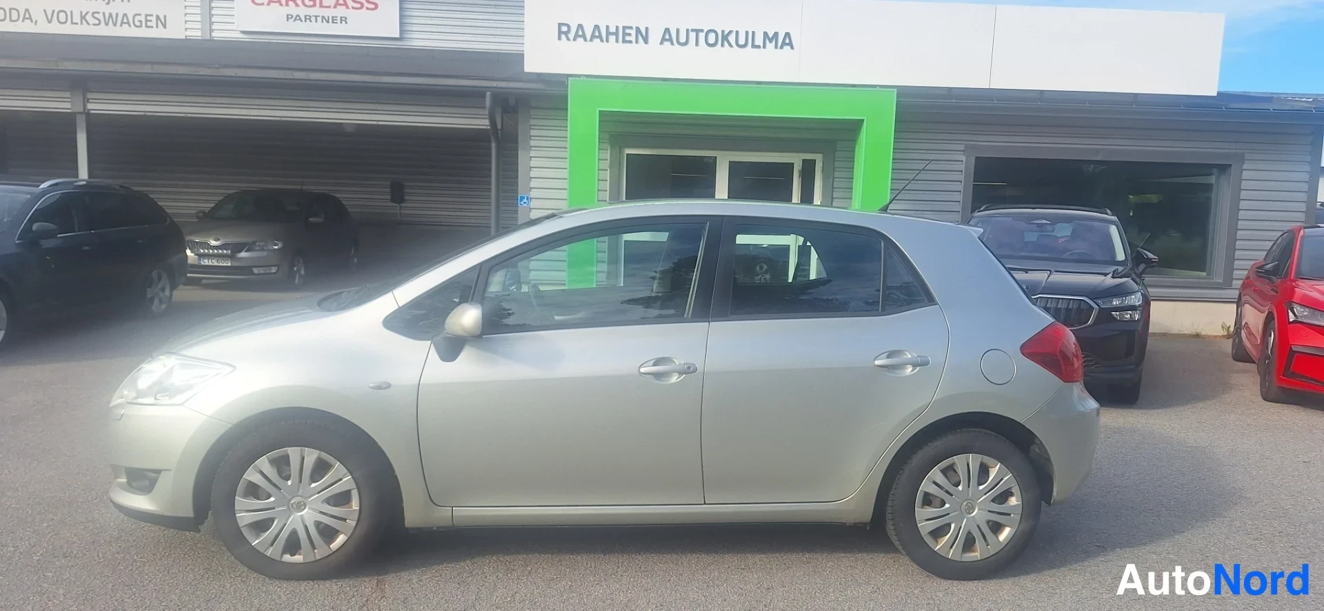 Sivulta: Hopeanvärinen Toyota Auris sivulta, viisiovinen viistoperä.