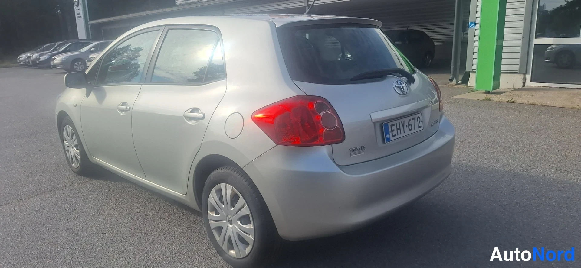 Takaviisto: Hopeanvärinen Toyota Auris viistosti takaa, rekisterikilpi.