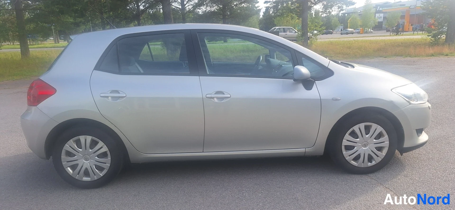 Sivulta: Sivukuvata hopeanvärinen viisiovinen hatchback; neljä ovea ja kattokaistale näkyvät selkeästi.