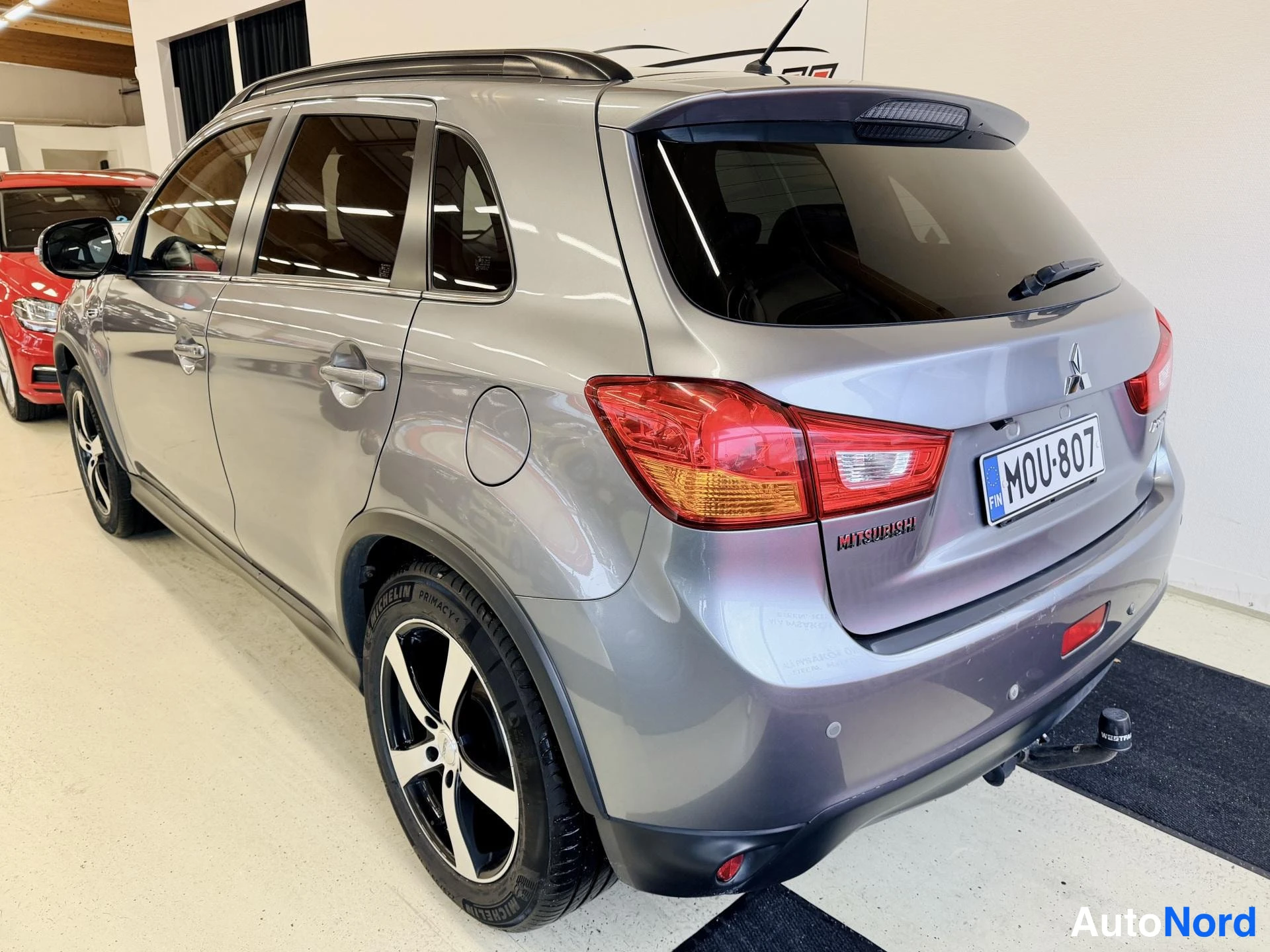Takaviisto: Harmaa Mitsubishi ASX takakulma vasemmalta, rekisteritunnus ja vetokoukku näkyvissä.