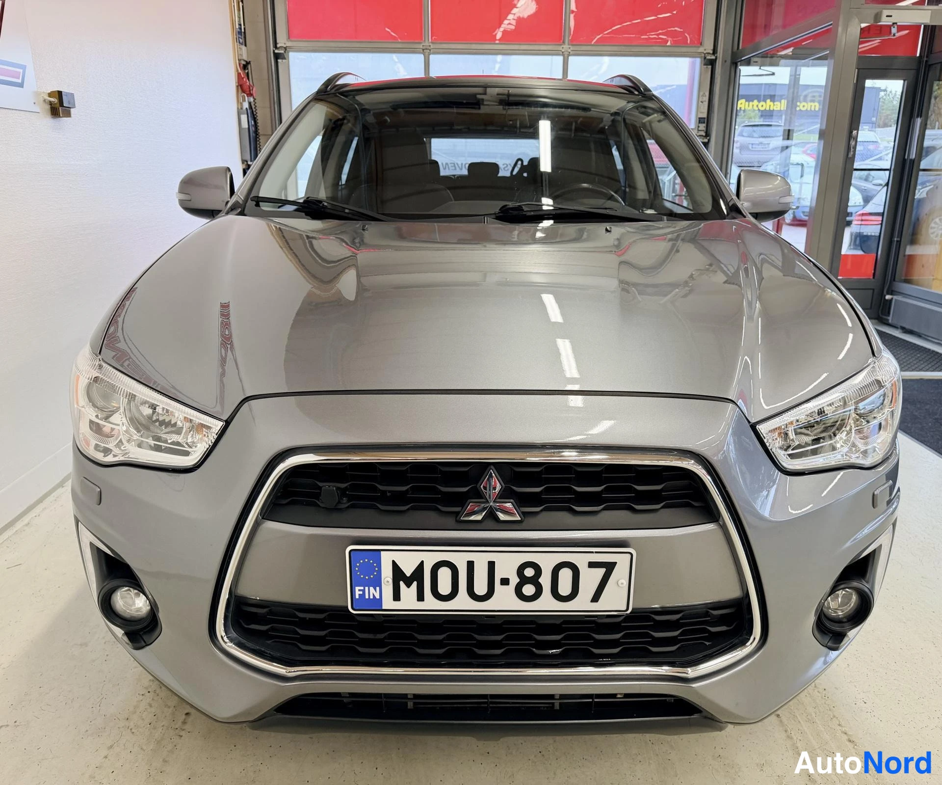 Edestä: Mitsubishi ASX edestä suoraan; kromikehys arvoiseen etusäleikköön, sumuvalot, -rekari.