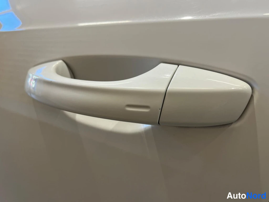 Yksityiskohta: Auton ovi myöhemmin lähikuva ovikahvasta, jossa pieni keyless-avaimen paikka.