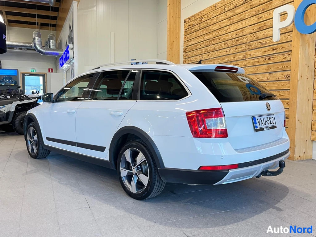 Takaviisto: Rear three-quarter right view of a white estate car: tail lamps, boot lid badge, license plate reading with FIN country code, rear bumper, parking sensors on th