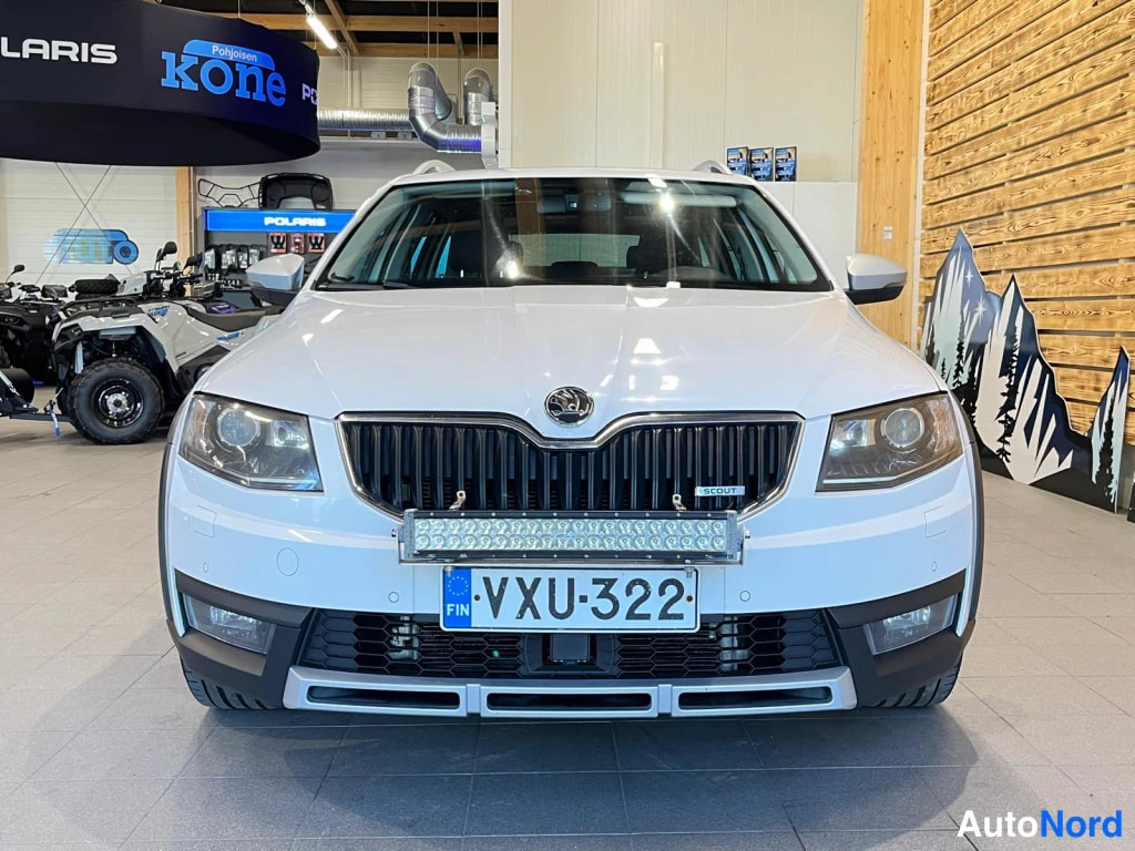 Edestä: Straight-on front view of a white station wagon featuring a horizontal LED light bar mounted on the grille above the registration plate.