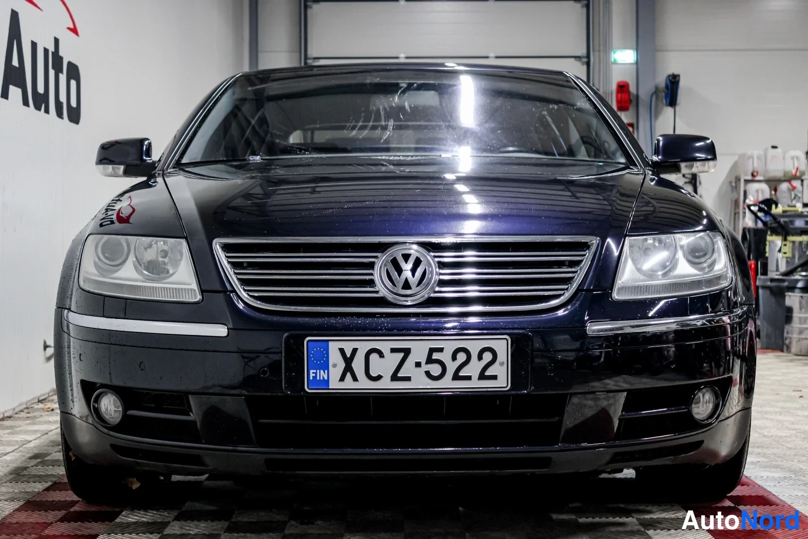 Edestä: Volkswagen Phaetonin etunäköymä, keulakoriste -rekisterikilvellä, tummansininen
