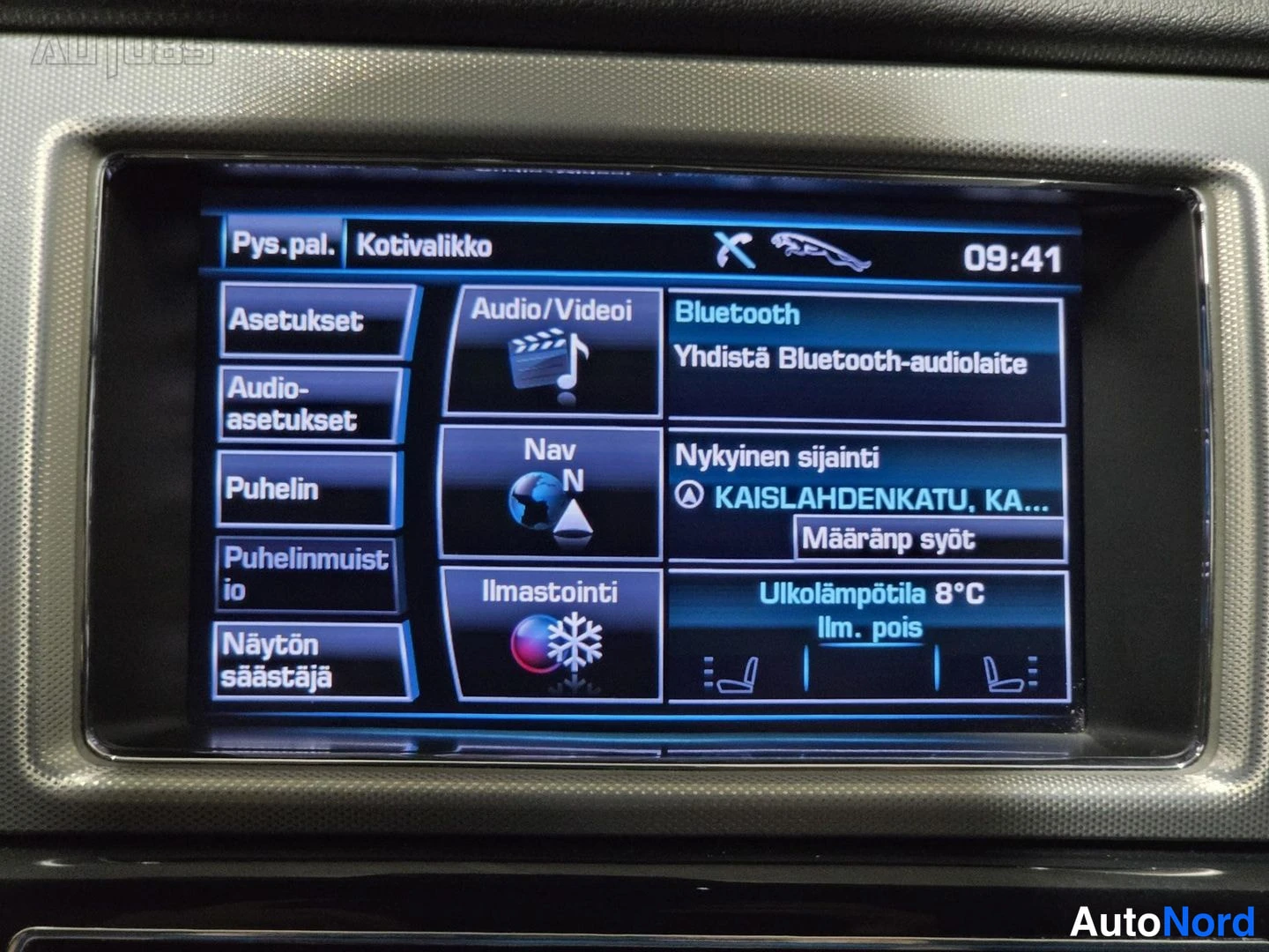 Muu: Viihde- ja navigointijärjestelmän näyttö lähikuvassa: kotivalikko valinnoilla Audio/Videoi, Nav, Ilmastointi, Puhelin ja Bluetooth; kello 09:41.