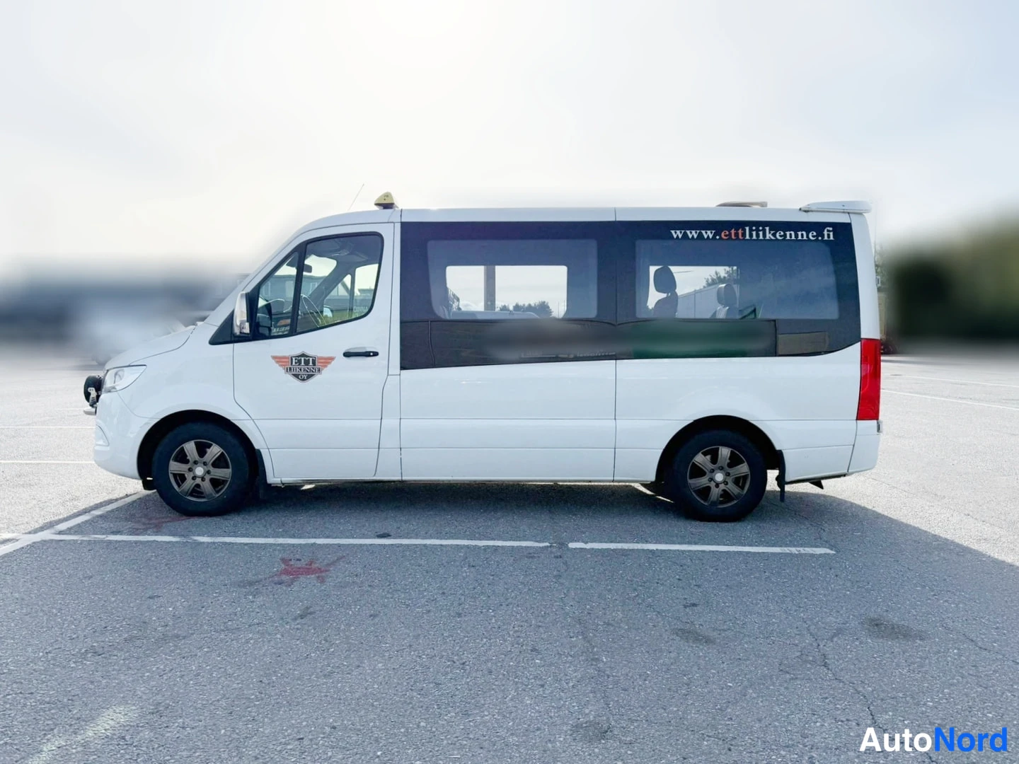 Sivulta: Valkoisen Mercedes-Benz Sprinter -taksin sivuprofiili; sivussa teksti www.taksikoski.fi.