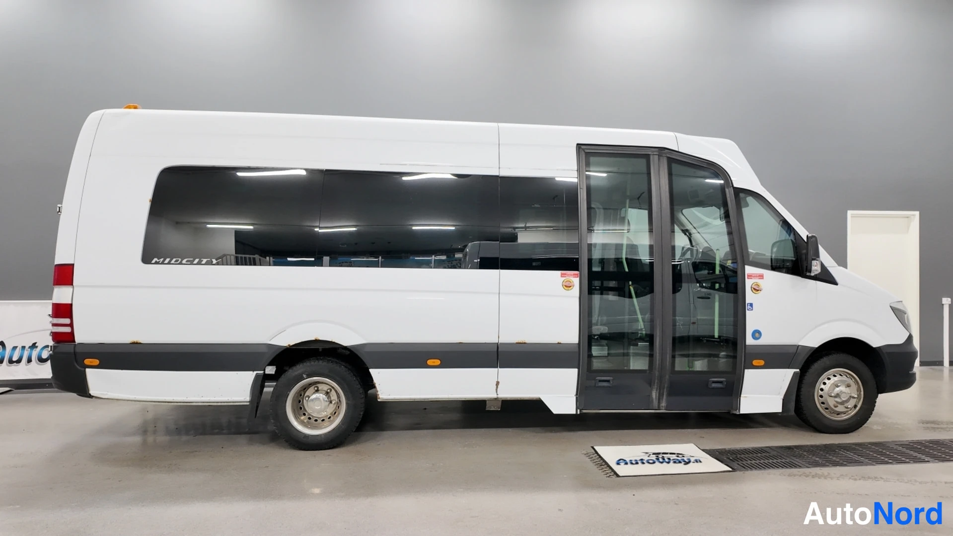 Sivulta: Mercedes-Benz Sprintin oikea kylki sivusta kuvattuna; liukuvieraan takaa avattu ovi ja tummat ikkunat.