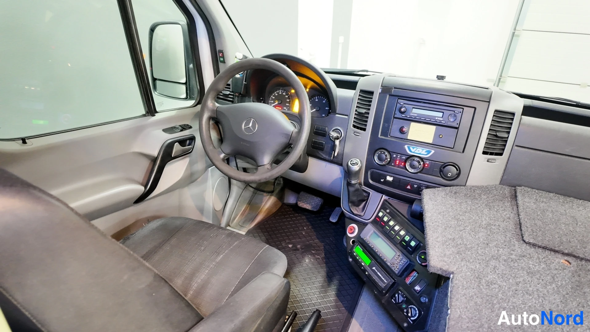 Takaviisto: Kuljettajan sivulta kuvattu Mercedes-Benzin ohjaamo: ratto ja kojelauta.