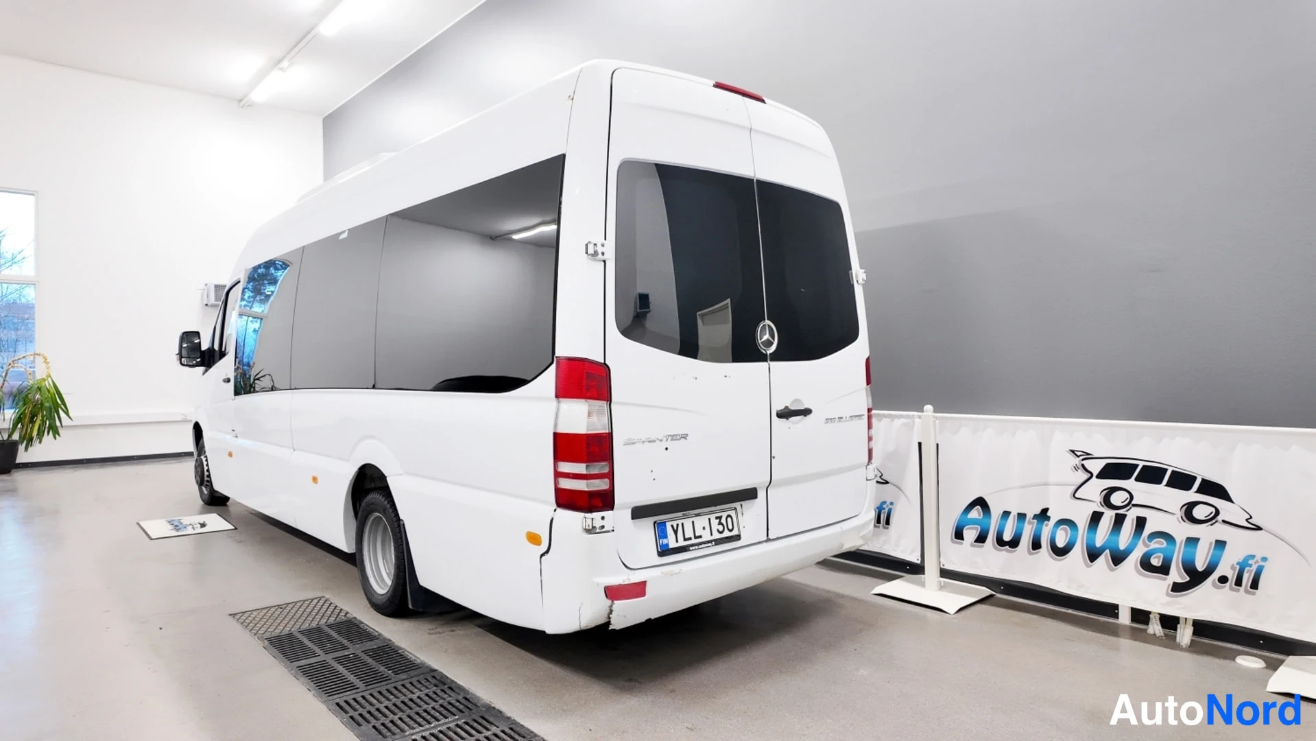 Takaviisto: Valkoinen Mercedes-Benz Sprinter takakulmasta, rekisterikilpi näkyvissä.