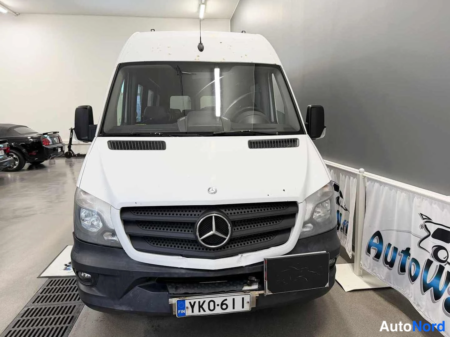 Edestä: Valkoisen Mercedes-Benz Sprinter -pakettiauton etunäkymä, rekisterikilpi
