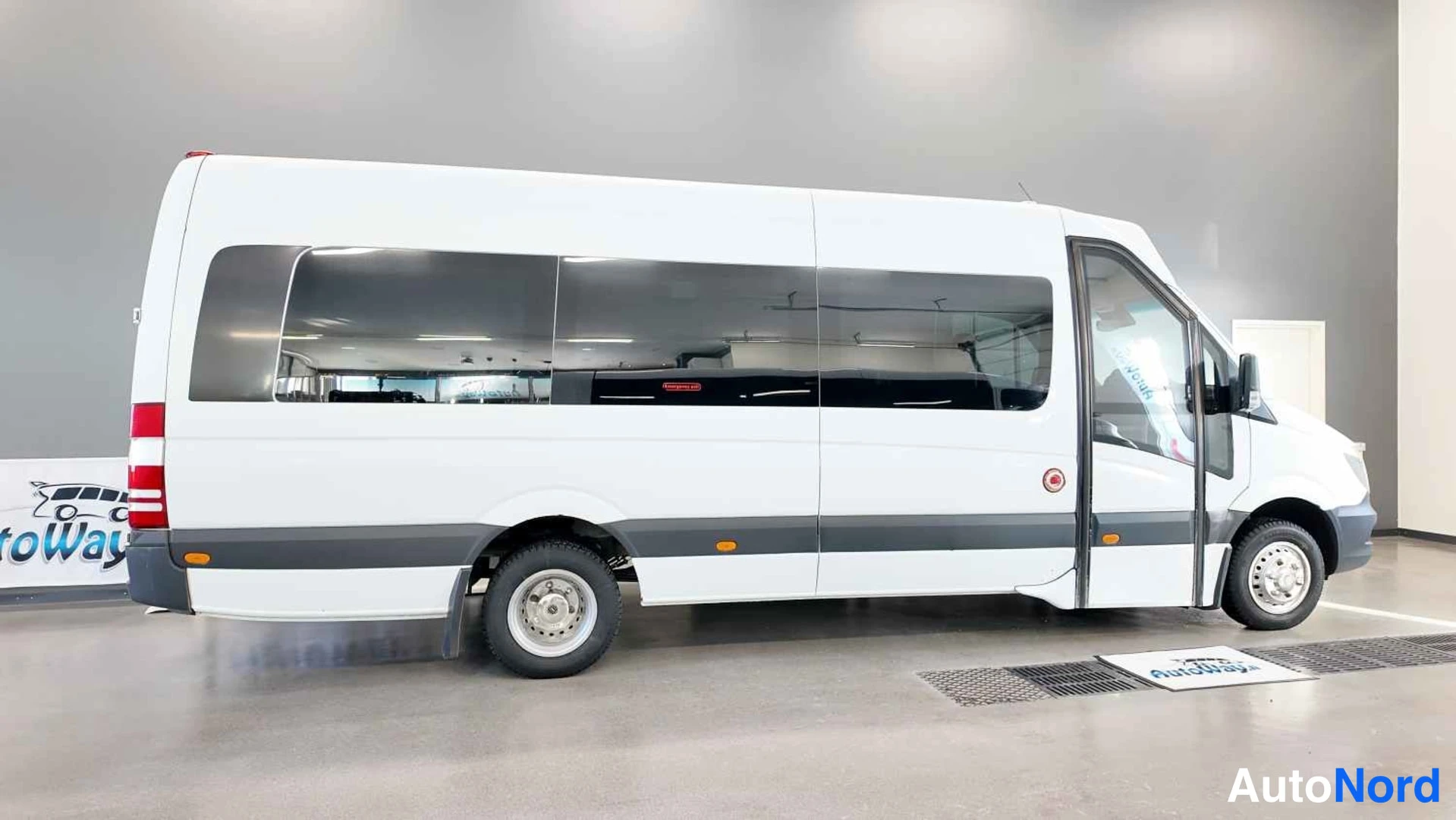 Takaviisto: Mercedes-Benz Sprinter -pakettiauto kuvattu kolmivartalosta takaa, nokka osoittaa oikealle. Auton korivalotus on valkoinen.