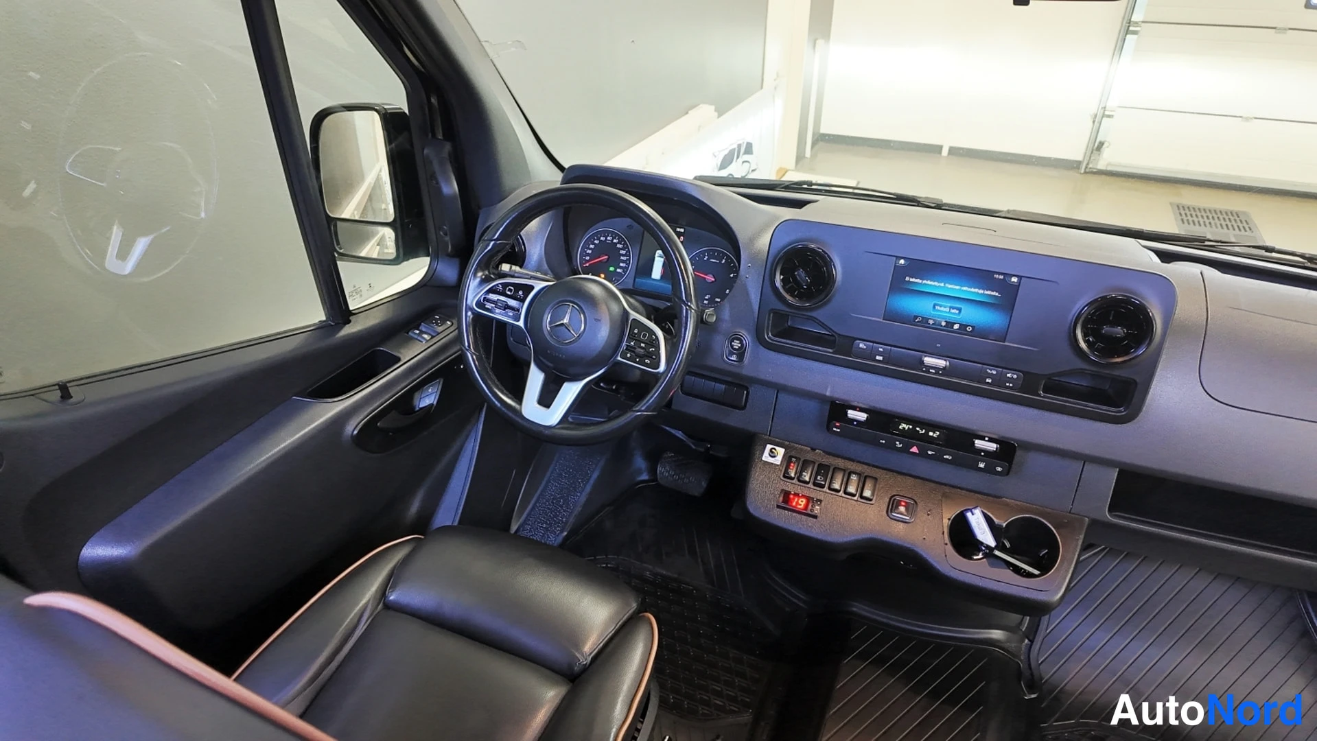 Muu: Mercedes-merkitty ohjauspyörä, mittaristo ja keskikonsoli infotainment-näytöllä, mustat penkit.